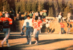 Lawson is running onto the field to help Coach Deschler get the Injured Alex Holtz off the field. Turns out it was all a ploy to stop the clock in a close game.