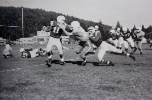 QB Butch Smith gives a Carson Senator a stiff arm as he breaks outside